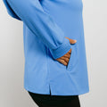 Blue quarter zip pullover with brown corduroy-lined pocket and person's hand visible.