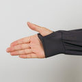Person's open hand wearing a charcoal gray quarter zip pullover with thumb extended upward.