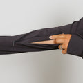 Person wearing charcoal gray quarter zip jacket with hand pulling sleeve zipper closed.