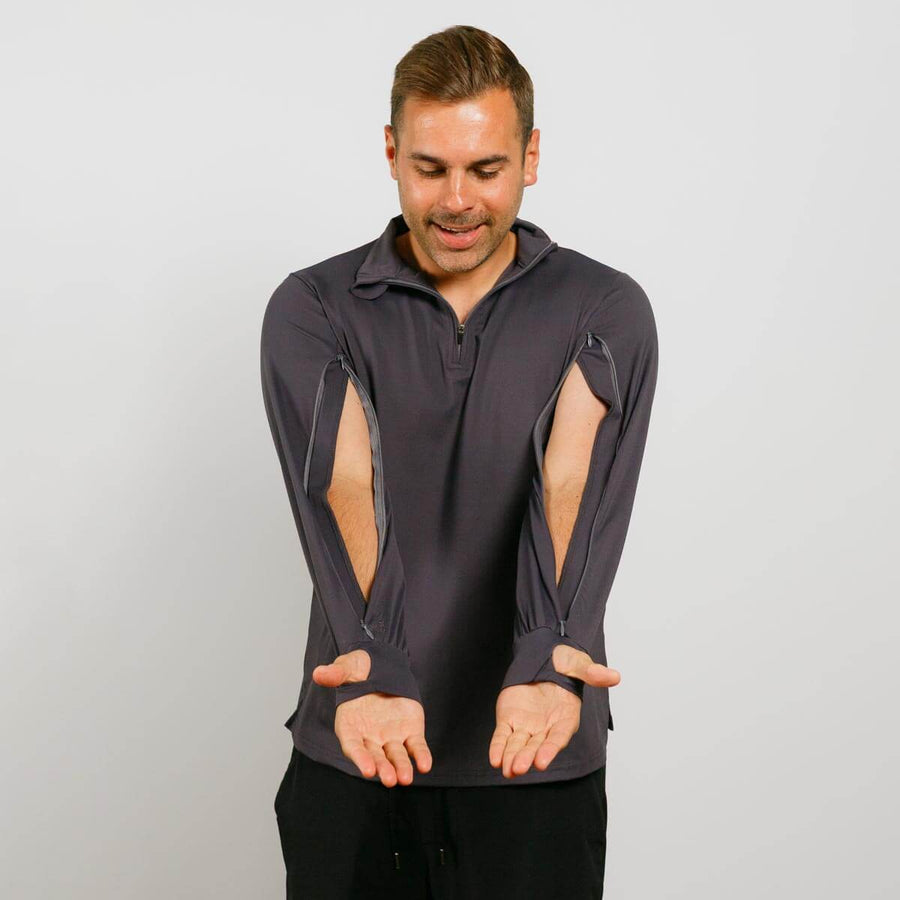 Man wearing dark gray quarter zip jacket with cutout sleeves against white background