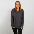 Woman wearing a charcoal quarter zip pullover with orange accents over black pants.