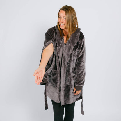 Woman wearing a gray velvet hooded robe over black leggings against a white background.