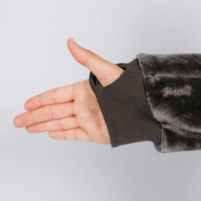 Hand extended from gray fleece sleeve showing open palm against neutral background.