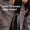 Person wearing open gray velvet robe with inner tie visible and black undergarment beneath.