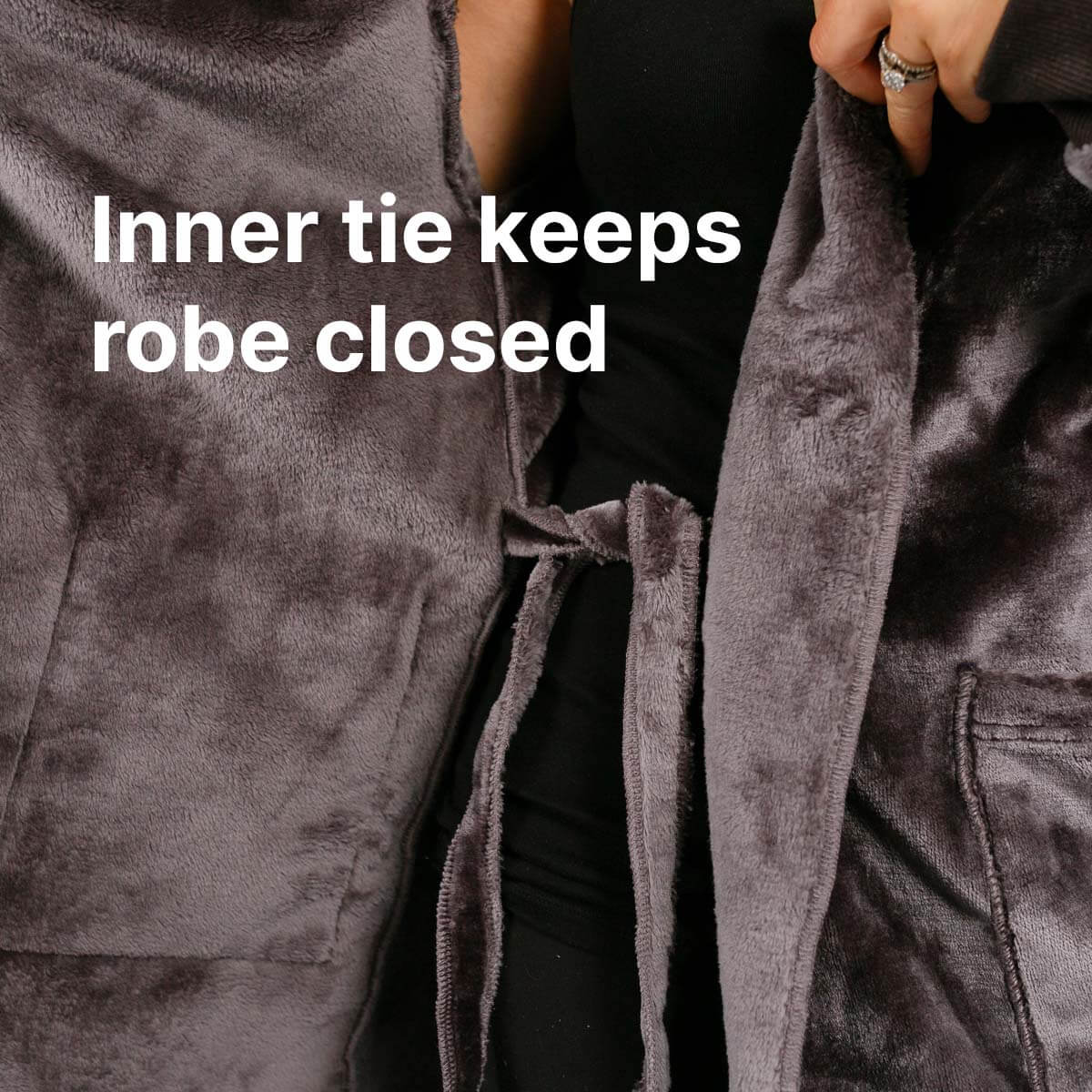 Person wearing open gray velvet robe with inner tie visible and black undergarment beneath.