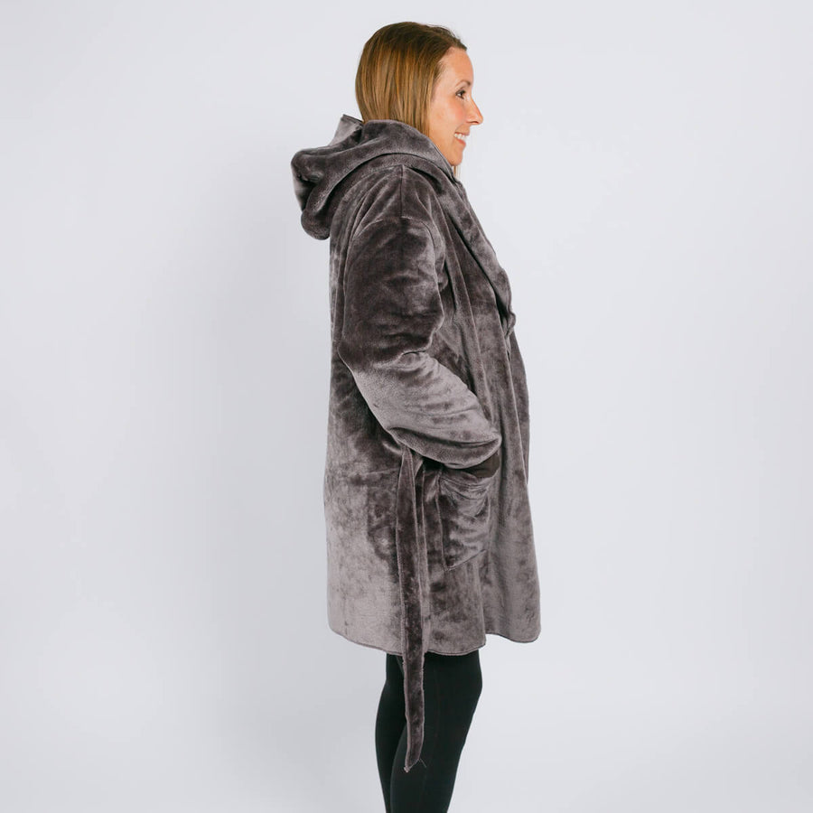 Woman wearing a gray velvet hooded robe with a belt, shown in profile view.