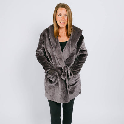 Woman wearing a gray velvet hooded robe with tie waist over black clothing.