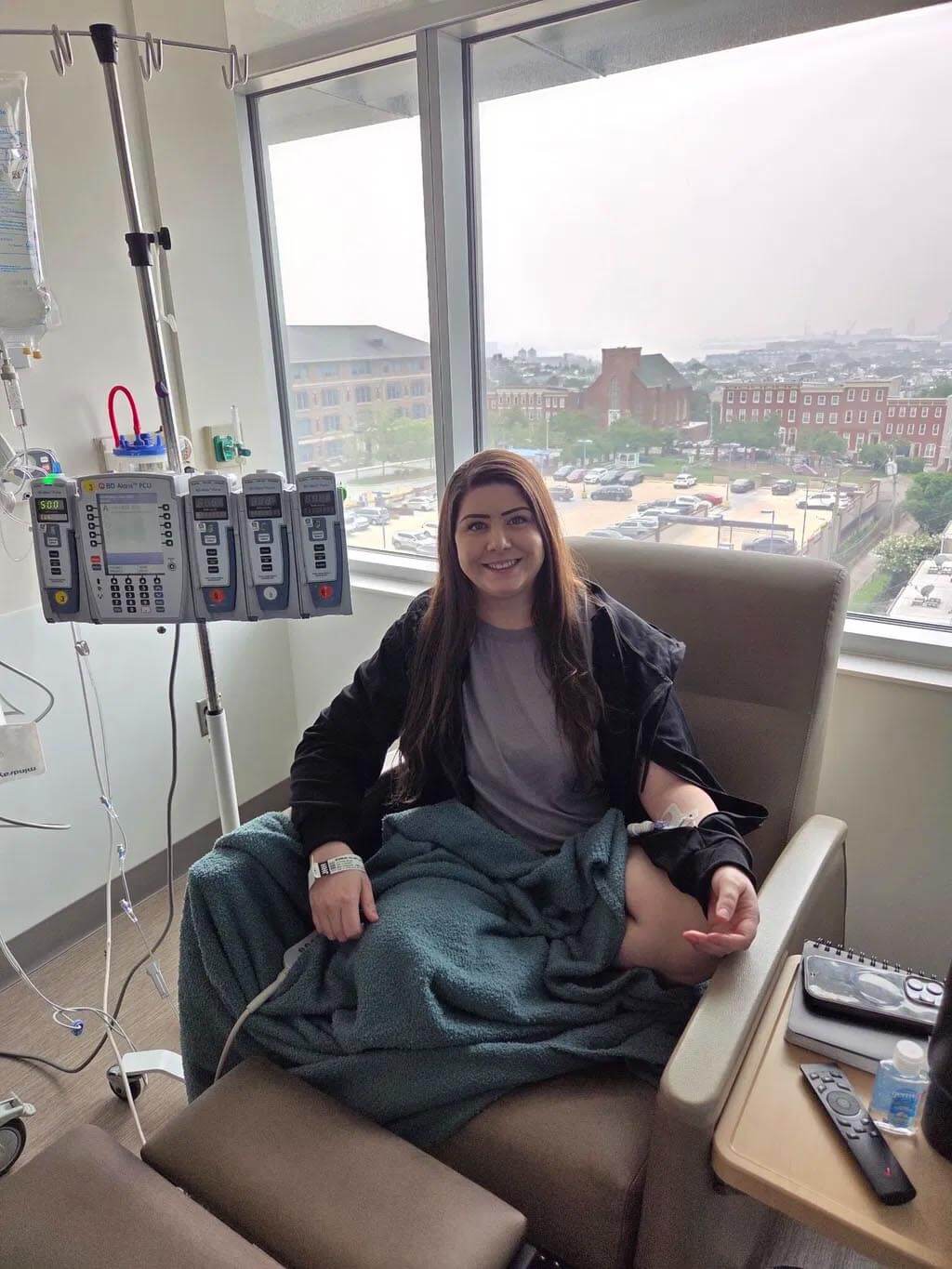 Patient in infusion chair wearing the BeWell IV Zip Hoodie
