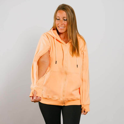 Woman wearing a peach-colored hoodie against a gray background #NEW | Model is 5'3" 130lbs wearing size S
