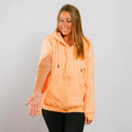 Woman wearing peach IV zip hoodie with side zipper access, front view.