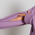 Person's hand opening a purple zip hoodie to show the interior lining and zipper detail.
