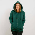 Woman wearing a dark green zip-up hoodie with drawstrings and front pockets against a white background.