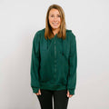 Woman wearing a dark green zip-up hoodie and black pants, smiling at camera.
