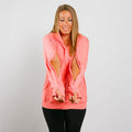 Woman wearing coral pink IV zip hoodie with chest port access zippers open, front view.