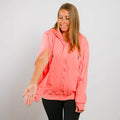 Woman wearing coral pink IV zip hoodie with left sleeve zipper access open.