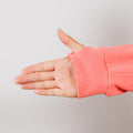 Person wearing coral IV zip hoodie with left sleeve zipper access detail visible.
