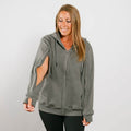 Woman wearing a gray zip-up hoodie with cutout sleeves over black pants, smiling downward. | Model is 5'3" 130lbs wearing size S
