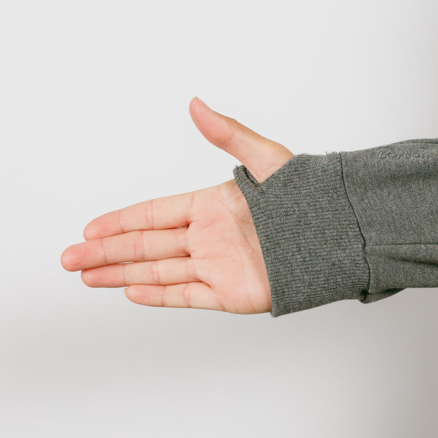 Person wearing olive green IV zip hoodie with left sleeve access zipper visible during treatment.