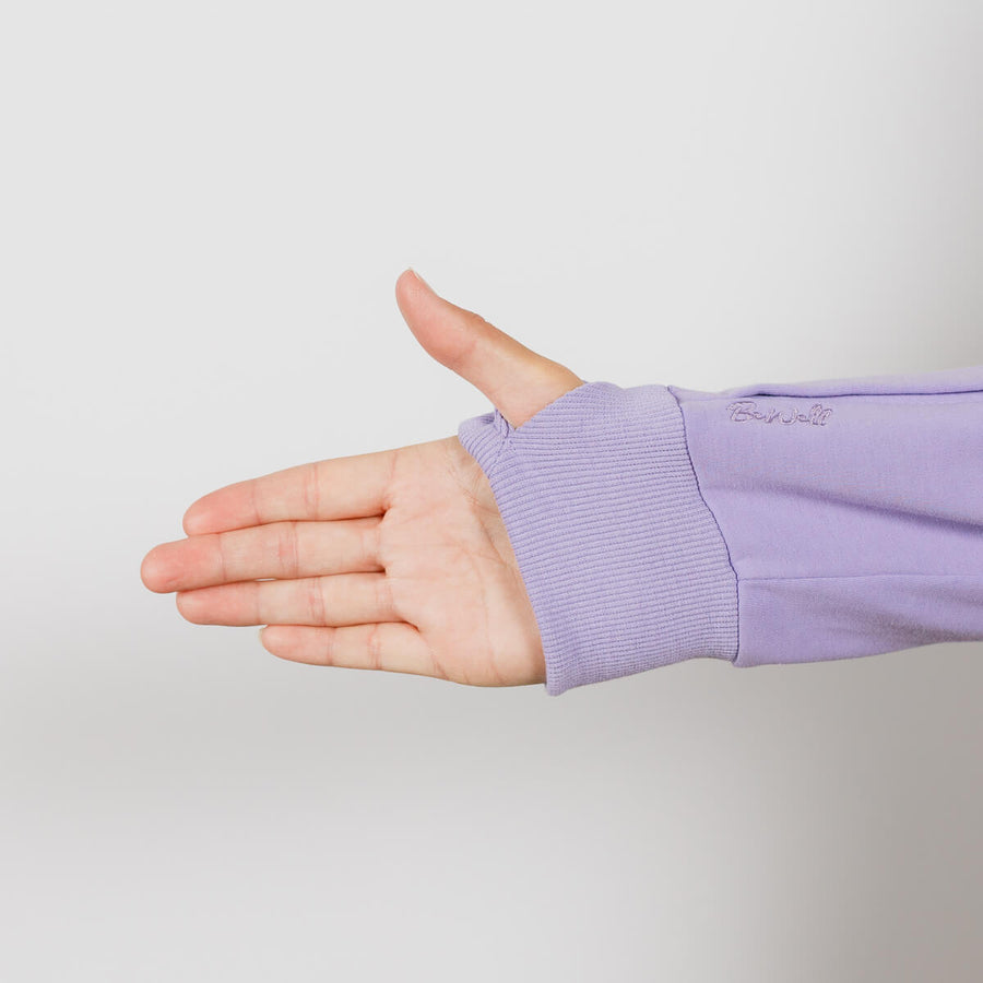 Person wearing lavender IV zip hoodie with left sleeve port access zipper visible.