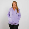 Woman wearing lavender zip hoodie with front zipper and kangaroo pockets, front view.