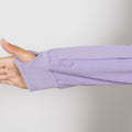 Woman wearing lavender IV zip hoodie with left arm zipper access open during treatment.