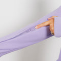 Woman wearing lavender IV zip hoodie, close-up of left sleeve zipper access feature.