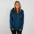 Woman wearing a navy blue zip-up hoodie with black pants, smiling at camera.