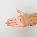 Close-up of beige IV zip hoodie sleeve showing wrist zipper access detail on person's arm.