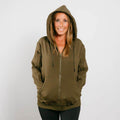 Woman wearing olive green IV zip hoodie with hood up, front view.