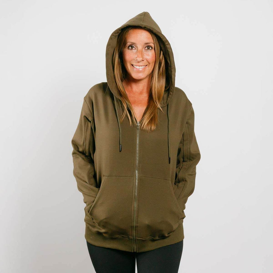 Woman wearing olive green IV zip hoodie with hood up, front view.