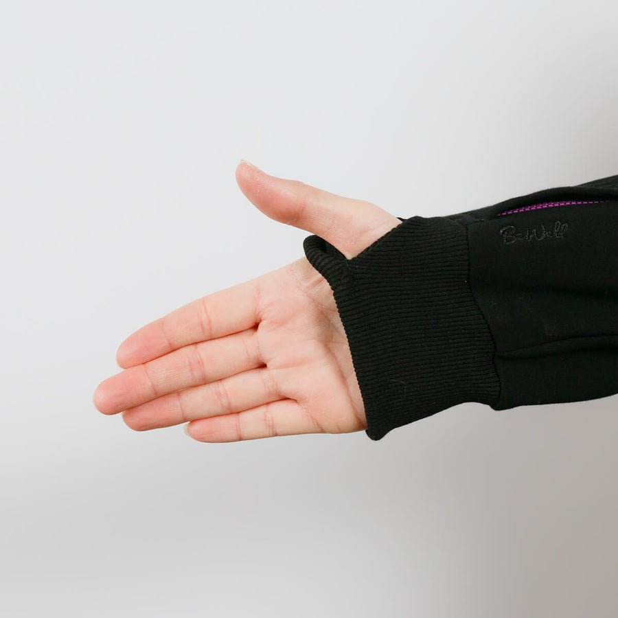 Person wearing black IV zip hoodie with left arm sleeve zipper access feature visible.