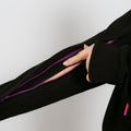 Person wearing black IV zip hoodie with purple zipper showing arm access opening.