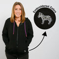 Woman wearing black IV zip hoodie with purple drawstrings and embroidered zebra detail.