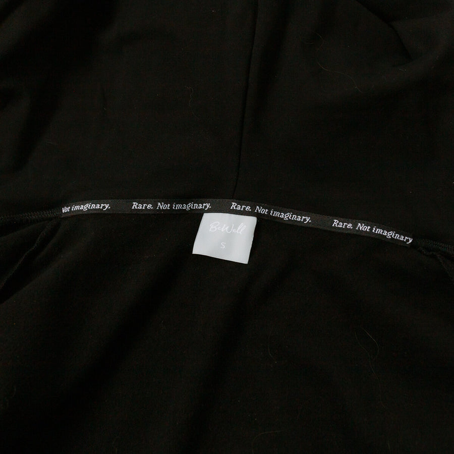 Close-up of black IV zip hoodie tag showing "Rare. Not imaginary" branding detail.