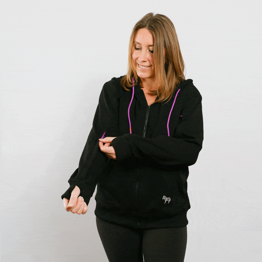 Woman wearing black IV zip hoodie with pink zipper accents, front view lifestyle shot.