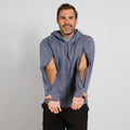 Man wearing a slate blue zip hoodie with open side cutouts, paired with black pants.  | Model is 5'8" 165lbs wearing size M