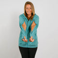 Woman wearing a turquoise zip hoodie with cutout details on the sleeves and torso, paired with black pants.