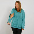 Woman wearing a turquoise zip-up hoodie with cutout sleeves and black pants against white background. | Model is 5'3" 130lbs wearing size S