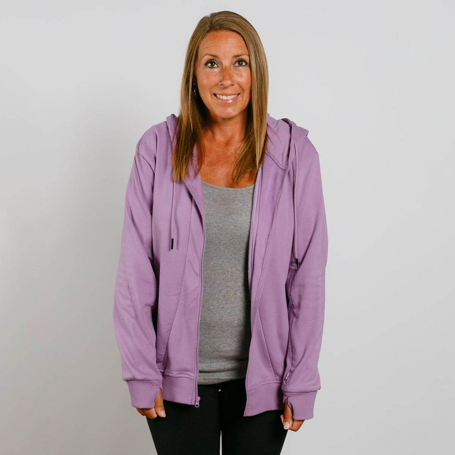 Woman wearing a purple zip-up hoodie over a gray shirt, smiling at camera.