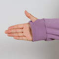 Hand extended from purple hoodie sleeve with ribbed cuff against neutral background.