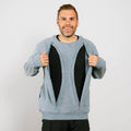 Man wearing open light blue crewneck sweatshirt over black shirt, smiling at camera. | Model is 5'8" 165lbs wearing size M