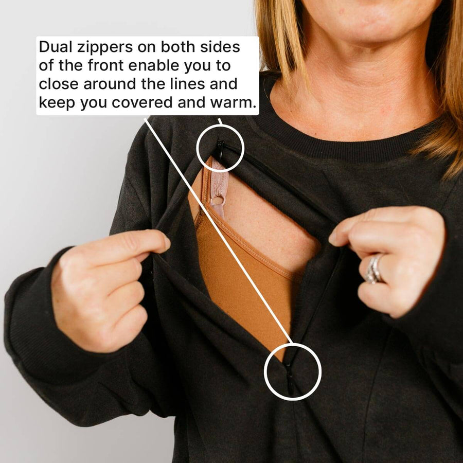 Woman wearing black crewneck with dual front zippers demonstrating chest access opening.