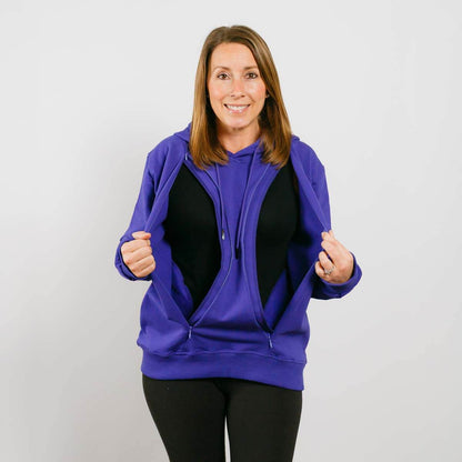 Woman wearing a purple zip-up hoodie over a black shirt, smiling at the camera. #NEW Multi-Access Hoodie Violet | Model is 5'3" 130lbs wearing size S
