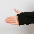 Person wearing black zip hoodie with left arm access zipper partially open.