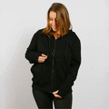 Woman wearing black zip hoodie with front zipper and drawstring, front view.