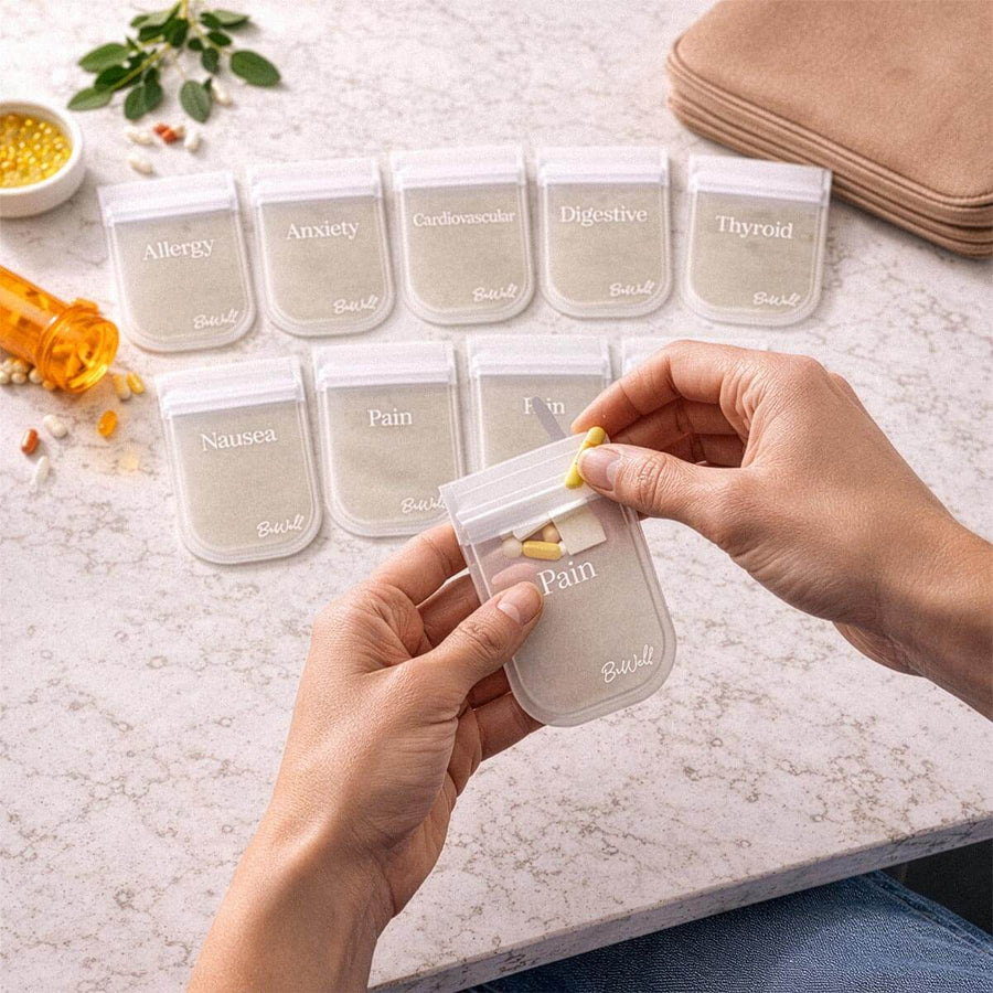 Person's hands holding beige mini pill pouch labeled "Pain" from set of ten labeled pouches.