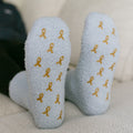 Light gray rest day socks with gold ribbon pattern, close-up front view.
