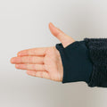 Person wearing black sherpa hoodie with left arm raised showing sleeve zipper access detail.
