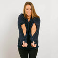 Woman wearing dark blue sherpa hoodie with open arm zippers, front view.