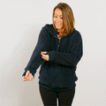 Woman wearing navy sherpa zip hoodie with left sleeve zipper access feature visible.